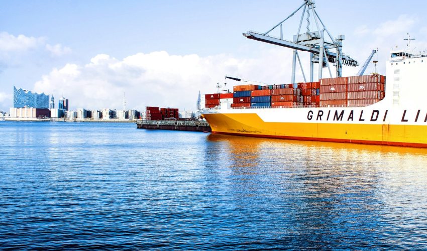 white and orange cargo ship with metal lifting equipment